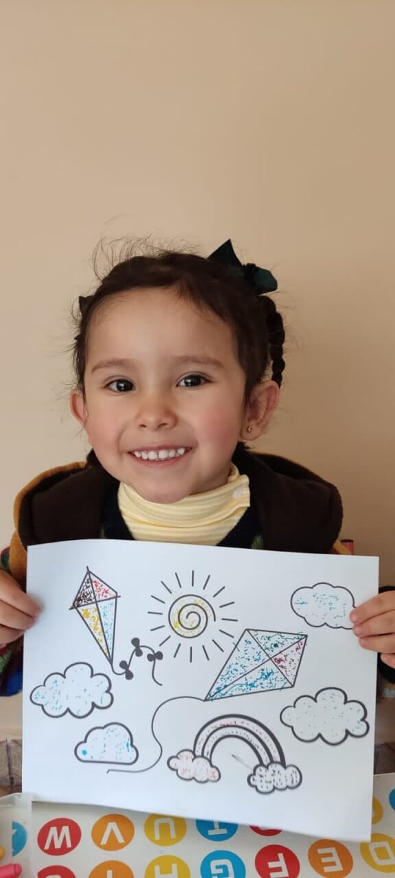Niña mostrando orgullosa su creación con elementos naturales